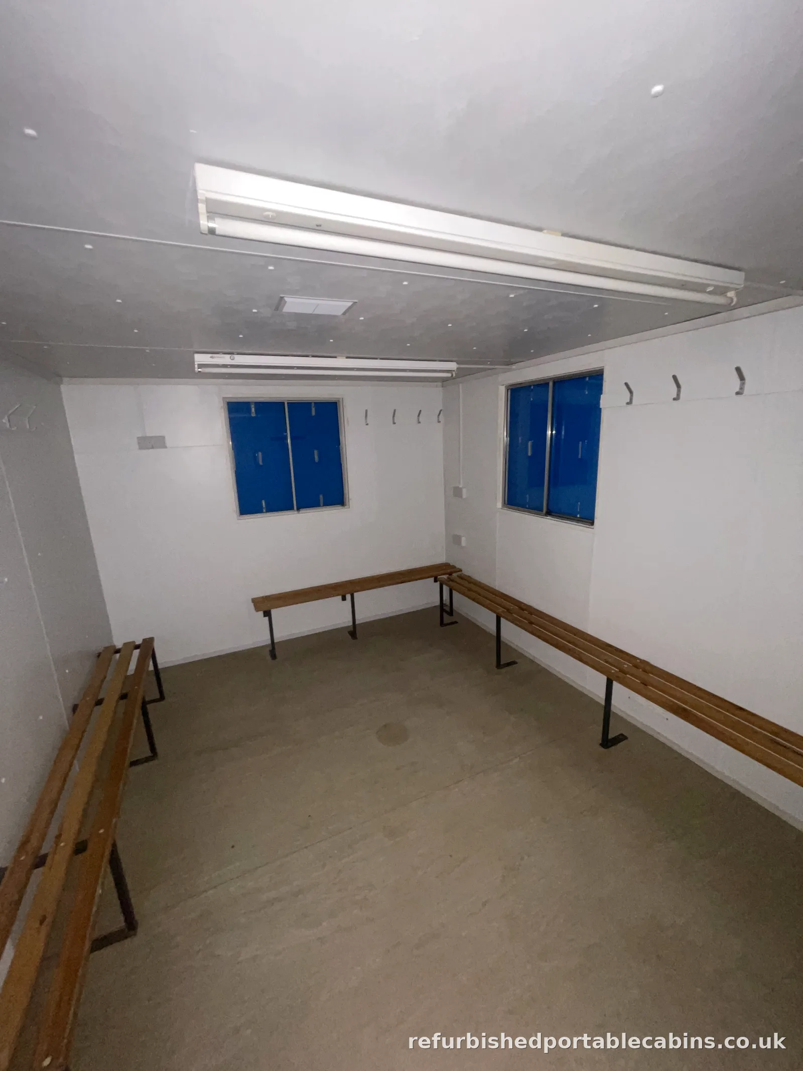 Refurbished changing room cabin with bench seating, hooks and lockers