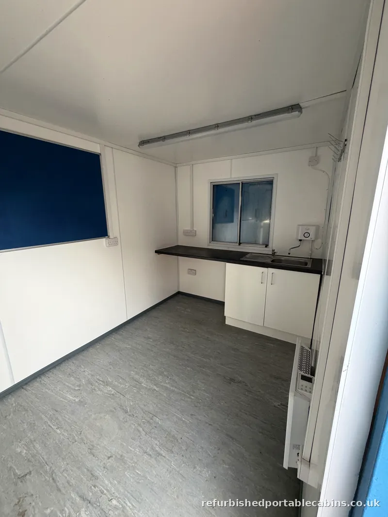Kitchen fitted in a refurbished portable cabin, with base units, worktop and sink