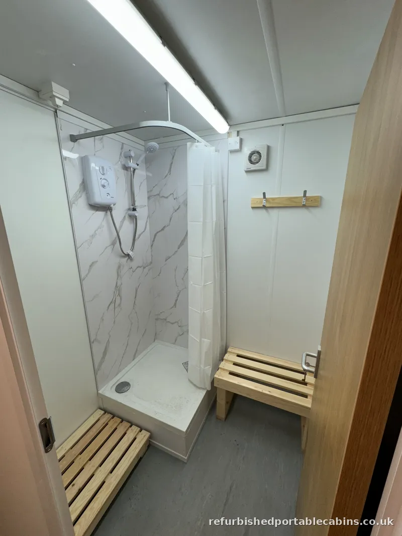 Showers Tiled shower cubicle and electric shower fitted in a refurbished portable cabin