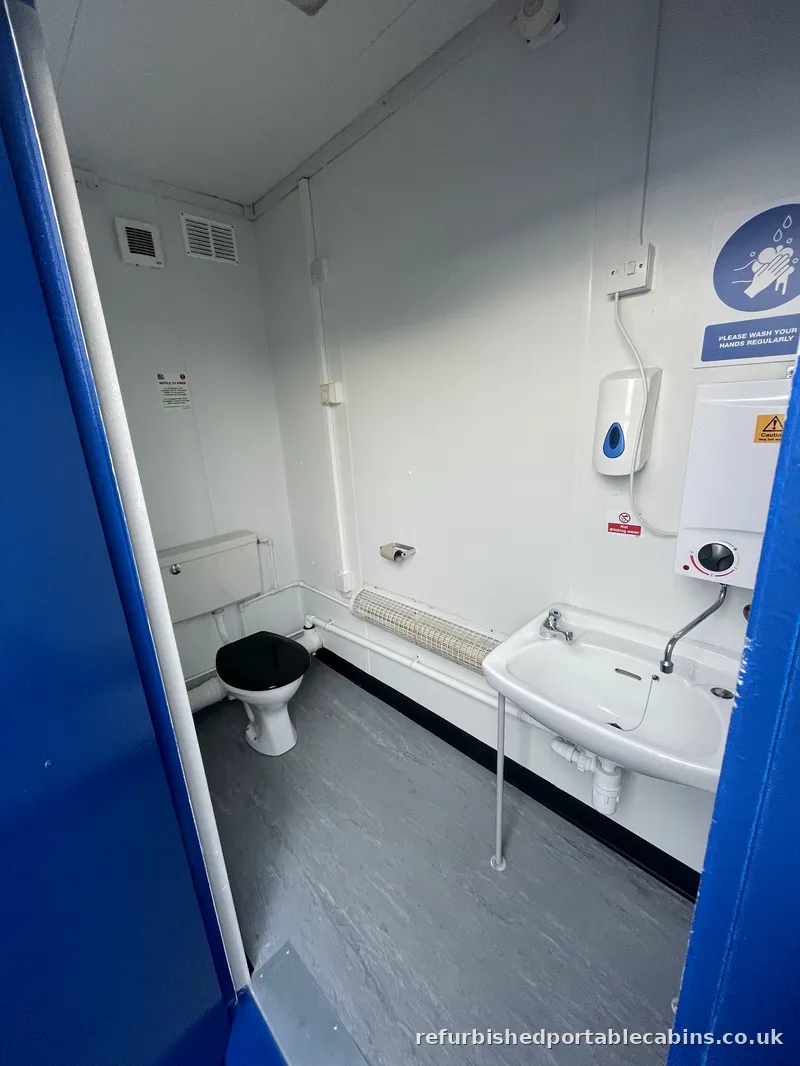 Toilets WC, basin and water heater in a refurbished portable cabin toilet