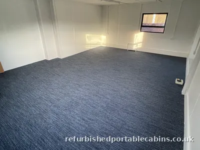 Carpeted open plan office fitted out in a refurbished portable cabin