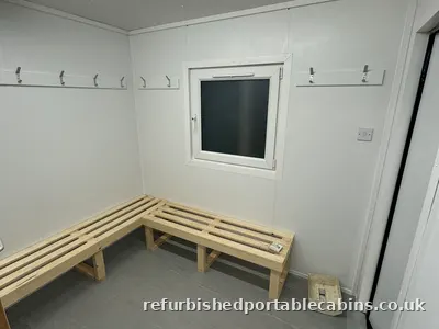 Bench seating and hooks along a refurbished cabin wall