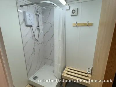Refurbished shower cabin with a tiled cubicle and electric shower
