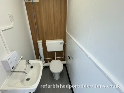 Toilet and wash basin in a refurbished portable cabin
