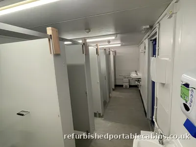 Refurbished toilet block with a row of cubicles and wash basins